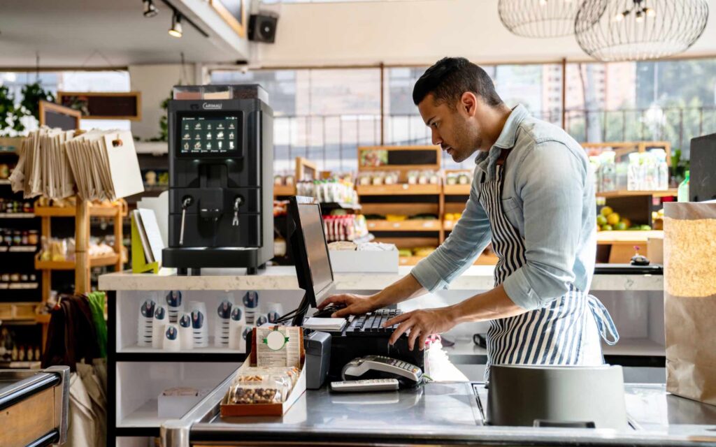 A barista uses a Carimali coffee machine.