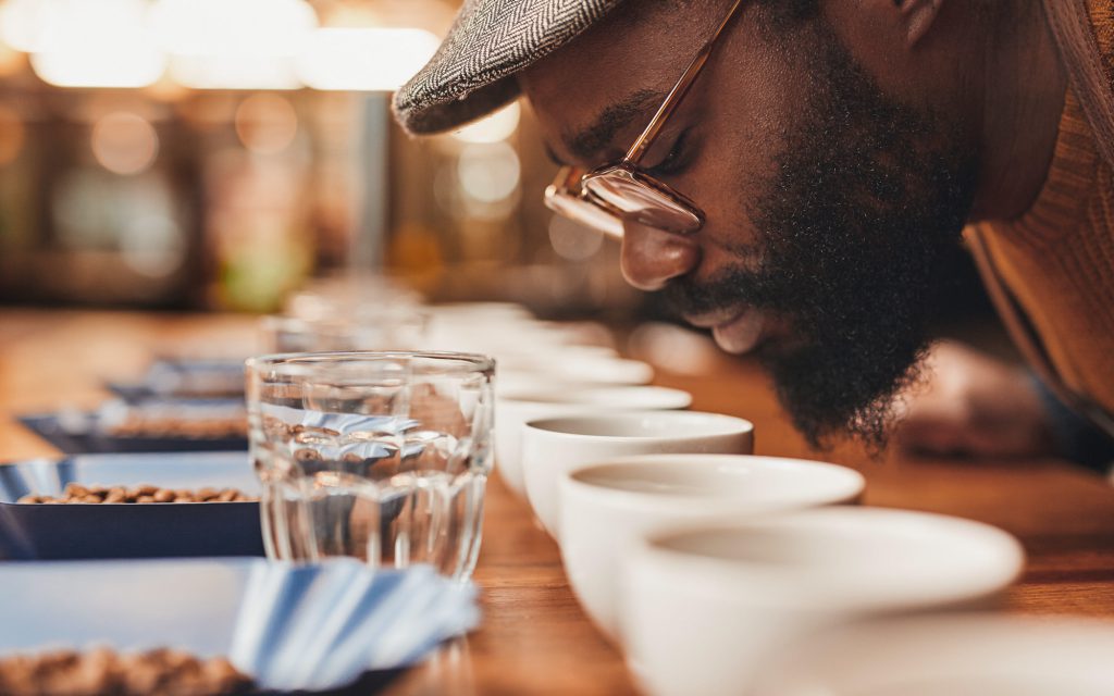 Nigerian man cupping several coffees