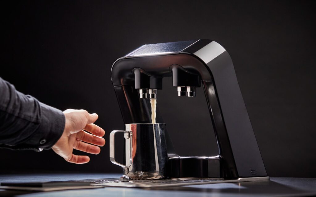 The Flo-Smart device pouring milk for a barista.