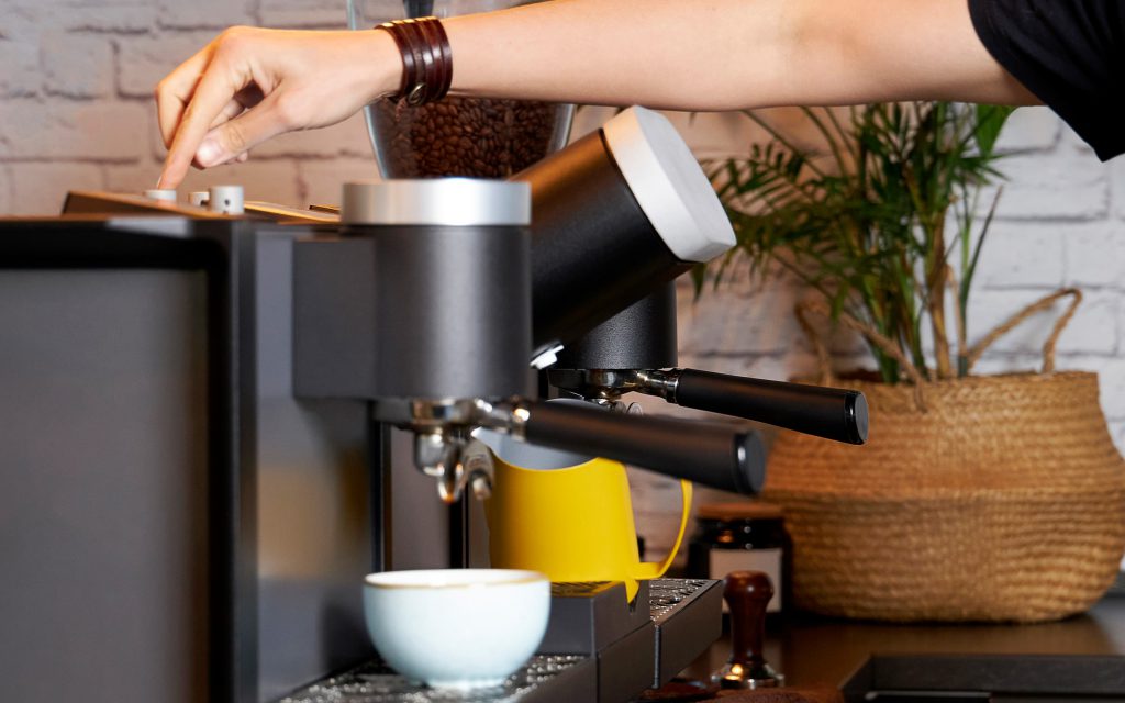 A barista uses a Heylo Coffee Module to prepare espresso.