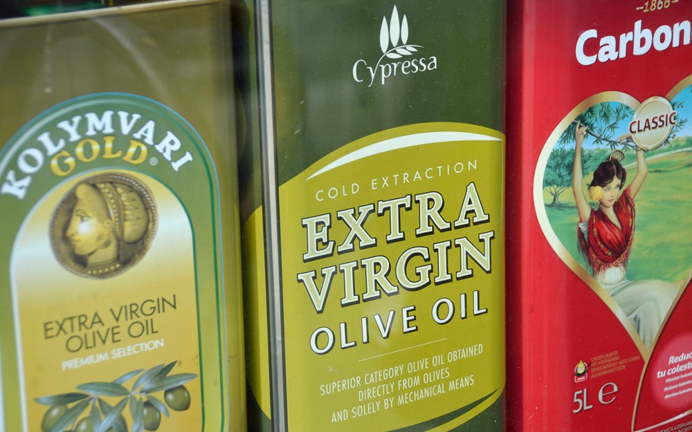 Various types of bottled olive oil in a supermarket.